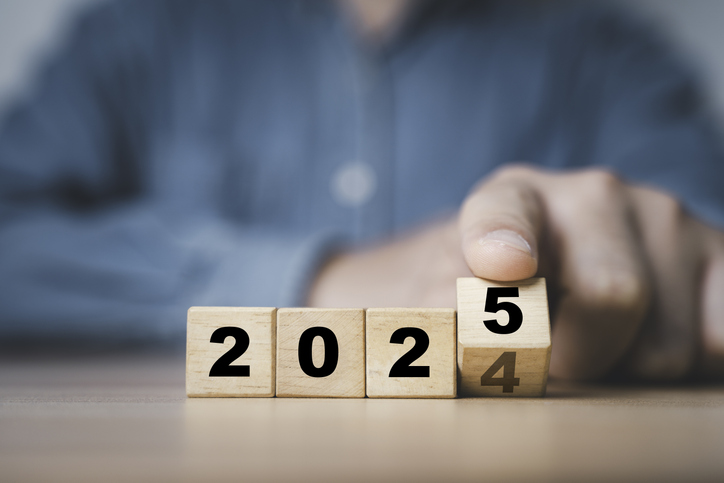 Businessman flipping of 2024 to 2025 on wooden block cube for preparation new year change and start new business target strategy concept.